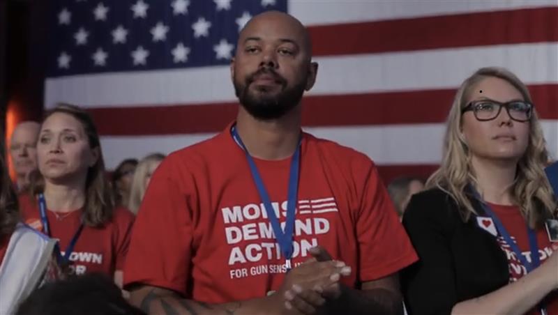 Khary Penebaker at Moms Demand Action event in front of American flag