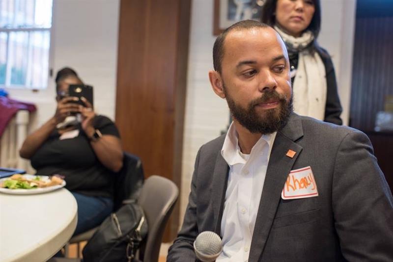 Khary Penebaker speaking at community event with microphone