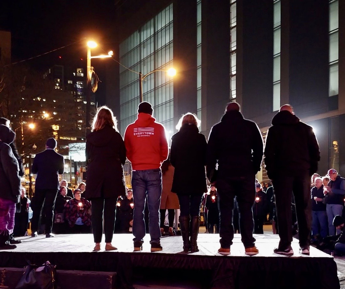 Khary Penebaker on stage at Everytown candlelight vigil with crowd holding candles