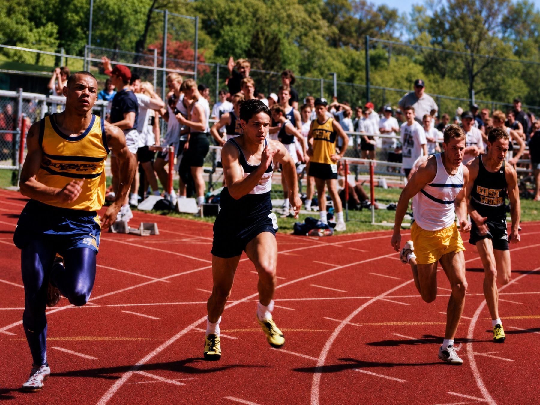 Khary as a high school sprinter in a gold jersey and royal-blue tights, leading a race at a track meet
